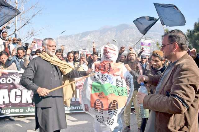 مظفر آباد: بھارتی یوم جمہوریہ پر احتجاجی مظاہرے کے دوران ایک شخص بھارتیوزیراعظم نریندرمودی کے پتلے کوڈنڈے سے ضرب لگارہا ہے