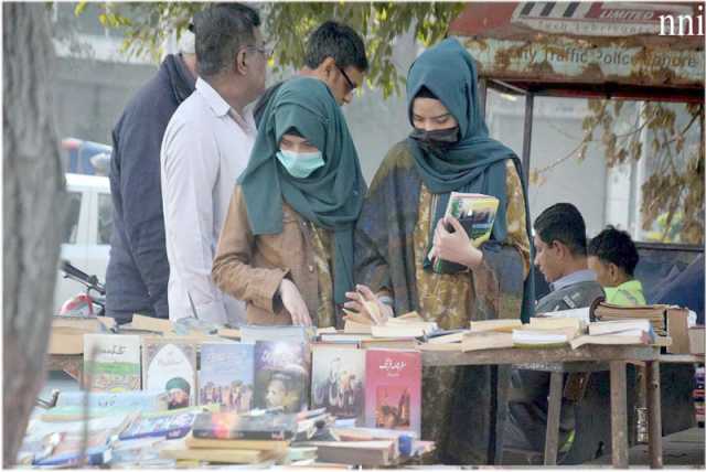 لاہور،شہری نیلا گنبد چوک میں لگے اسٹالز پر کتابیں دیکھ رہے ہیں