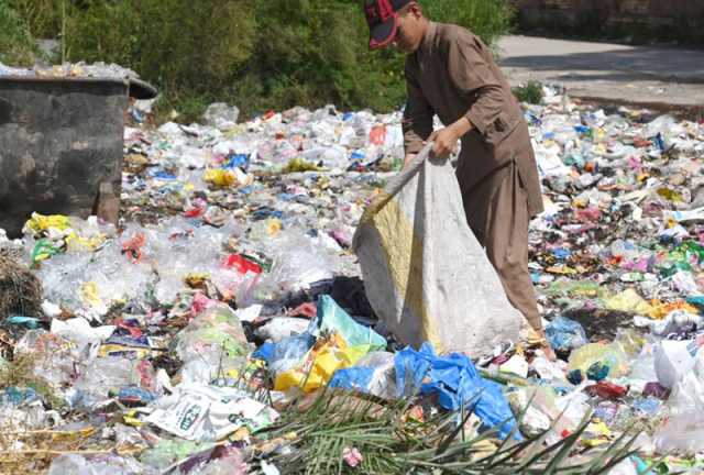 لاڑکانہ: ایک بچہ سڑک کنارے موجود کچرے کے ڈھیر سے کارآمد اشیاء تلاش کرتے ہوئے