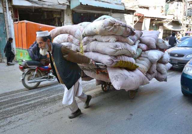 پشاور،ایک بزرگ محنت کش بھاری ہتھ گاڑی گھسیٹ کر لے جارہاہے